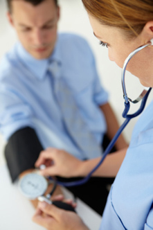 Female Doctor Taking Blood Pressure of Male Patient