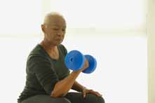 Older Woman Lifting Weights While Sitting